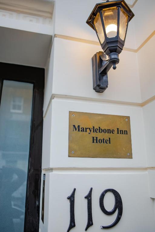 a sign for a hotel with a light on the wall at Marylebone Inn in London