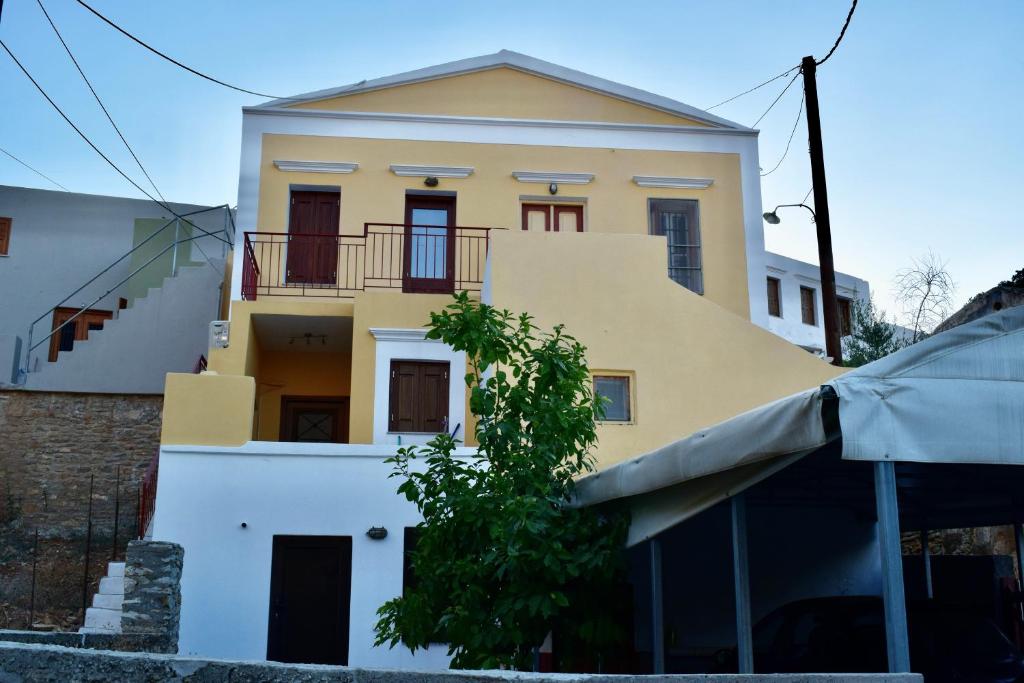 a yellow and white house with a balcony at ΚΟΥΛΟΥΝΤΡΗ (1) in Symi