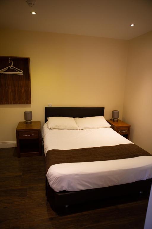 a bedroom with a large bed and two night stands at Marylebone Inn in London
