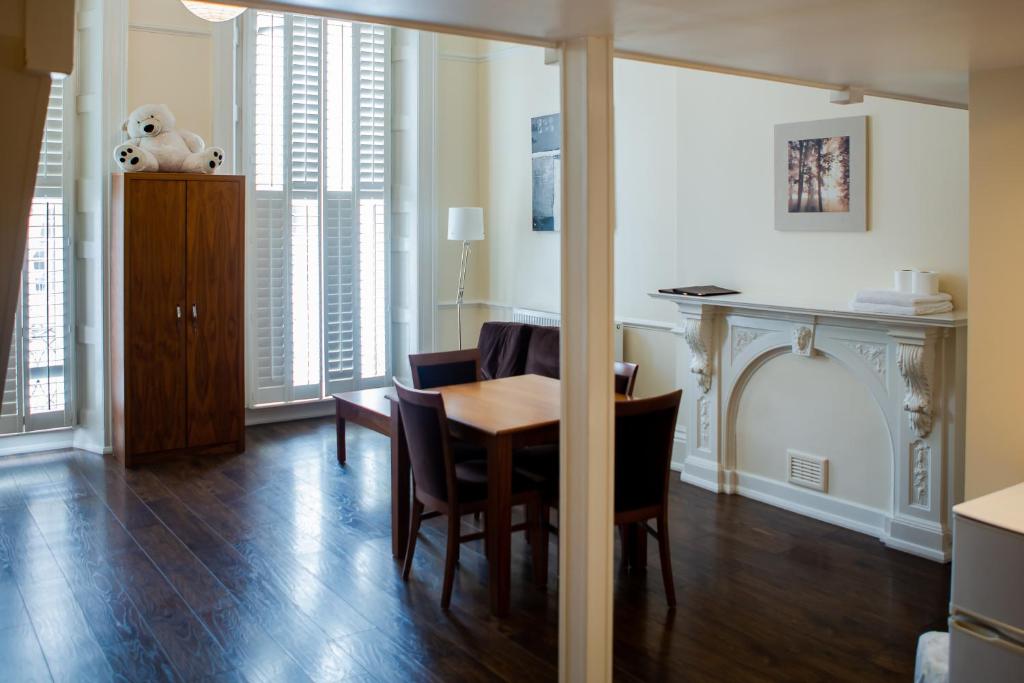 a living room with a dining room table and chairs at Marylebone Inn in London