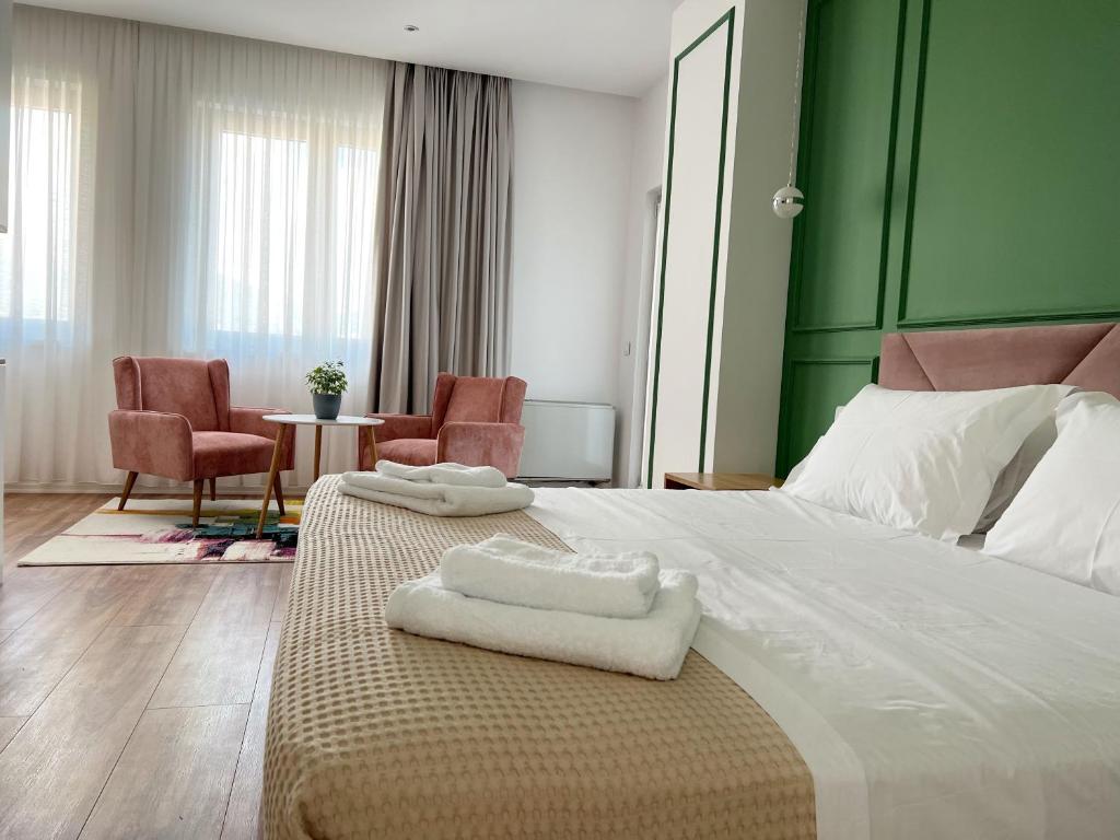 a hotel room with a bed with towels on it at Ginger Home Tirana in Tirana