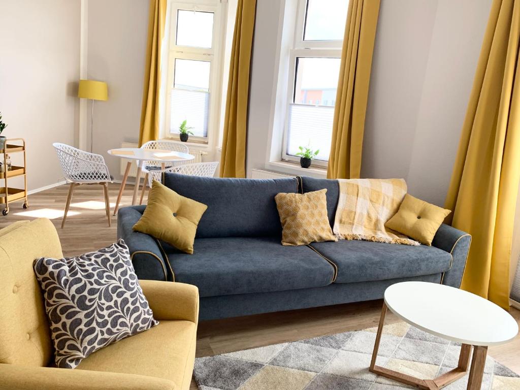 a living room with a blue couch and chairs at Lovely City-Apartment*Tiefgarage,Zentrum,BTU* in Cottbus