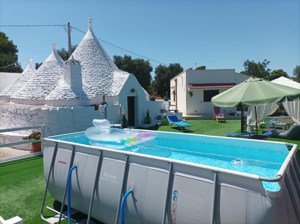 einen Pool in einem Hof mit einem Haus in der Unterkunft Trullo Libellula in Ceglie Messapica
