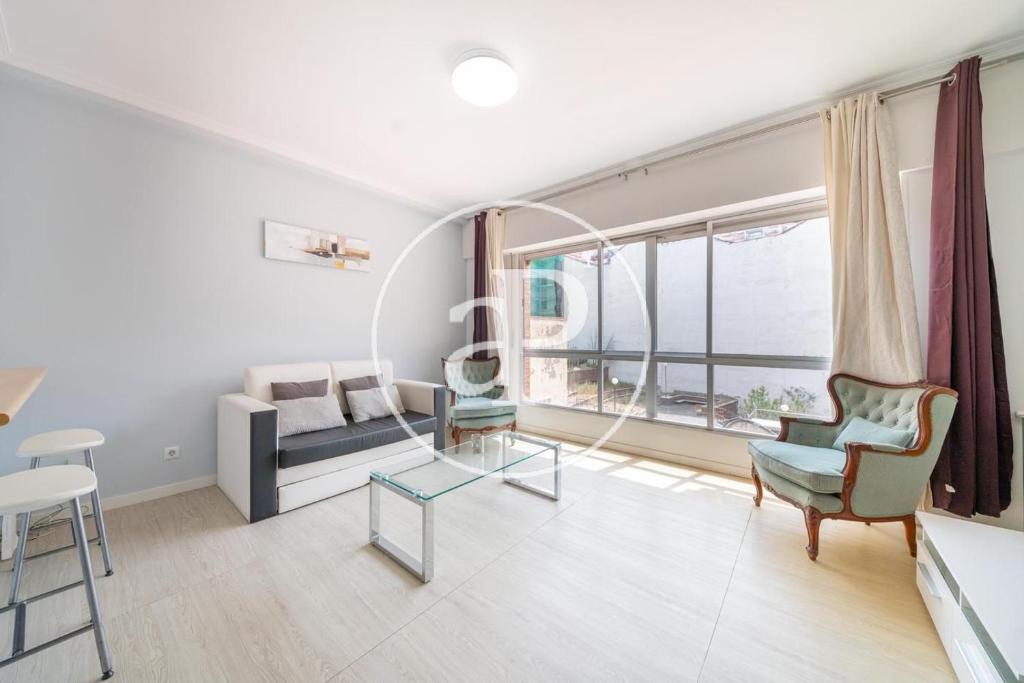 uma sala de estar com um sofá e uma janela em Madrid Central, Apartamento Plaza de España em Madri