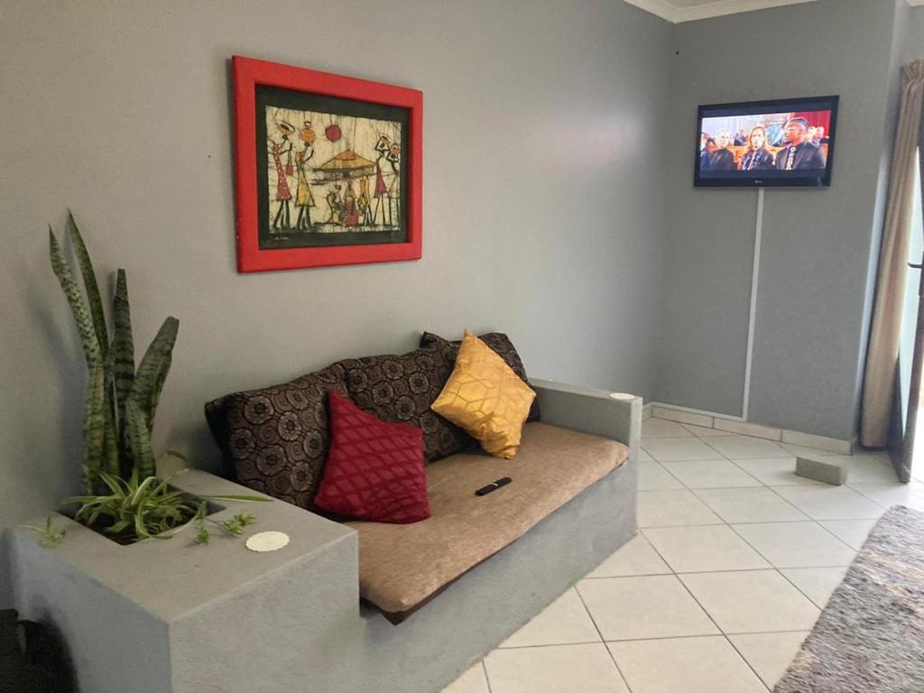 a living room with a couch with pillows on it at Daffodil self catering and accommodation A in Swakopmund