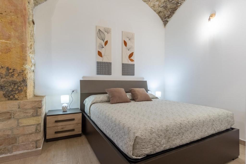 a bedroom with a bed and a brick wall at Casa Vacanza Home MAF in Cagliari