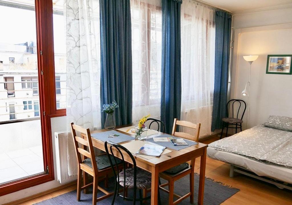 ブダペストにあるCasaLara-Cozy Nest Near Buda Castleのテーブル、椅子、ベッドが備わる客室です。