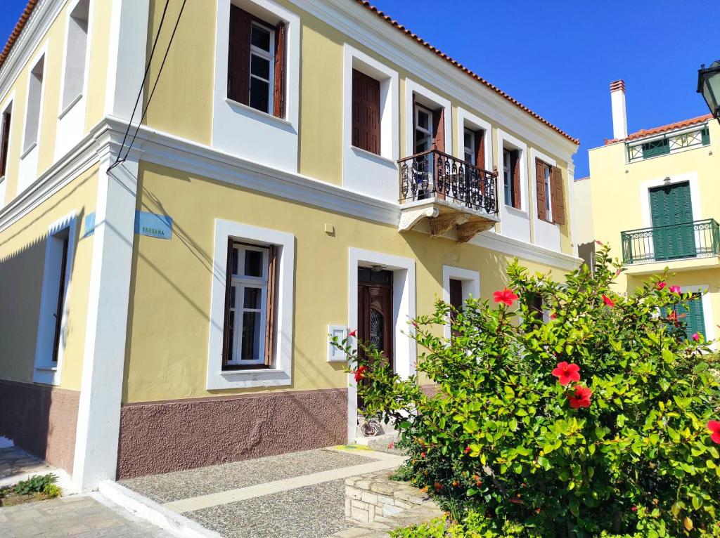 a yellow and white building with a balcony at SOTIRIA in Pythagoreio