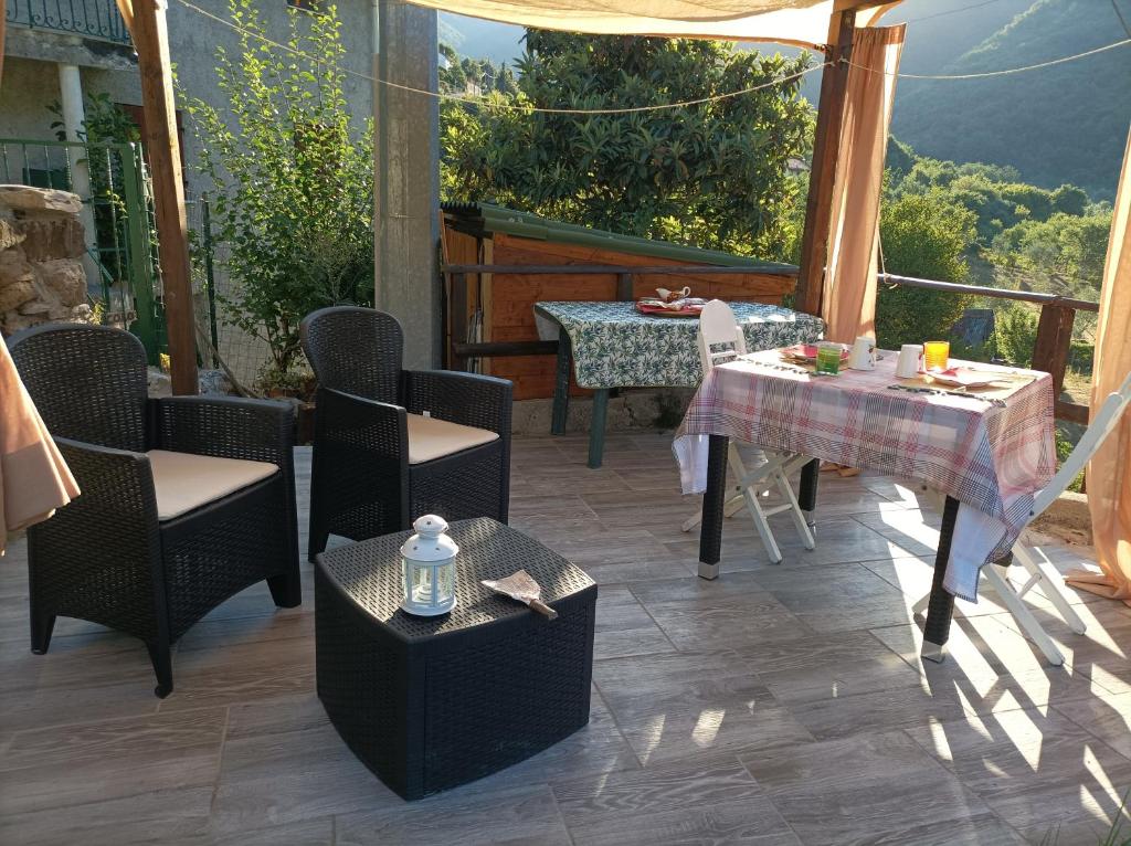 un patio con mesa y sillas y vistas a la montaña en lotus flower en Sant'Olcese