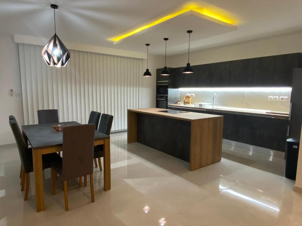a kitchen and dining room with a table and chairs at Modern, Spacious, 3 Bedroom Apartment near Malta International Airport in Luqa