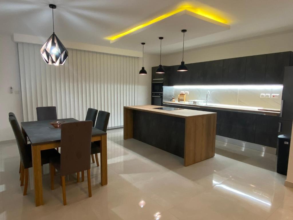 cocina y comedor con mesa y sillas en Modern, Spacious, 3 Bedroom Apartment near Malta International Airport en Luqa