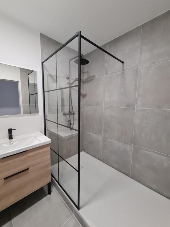 La salle de bains est pourvue d'une douche en verre et d'un lavabo. dans l'établissement Bassin d'Arcachon Villa 10 couchages, à Andernos-les-Bains