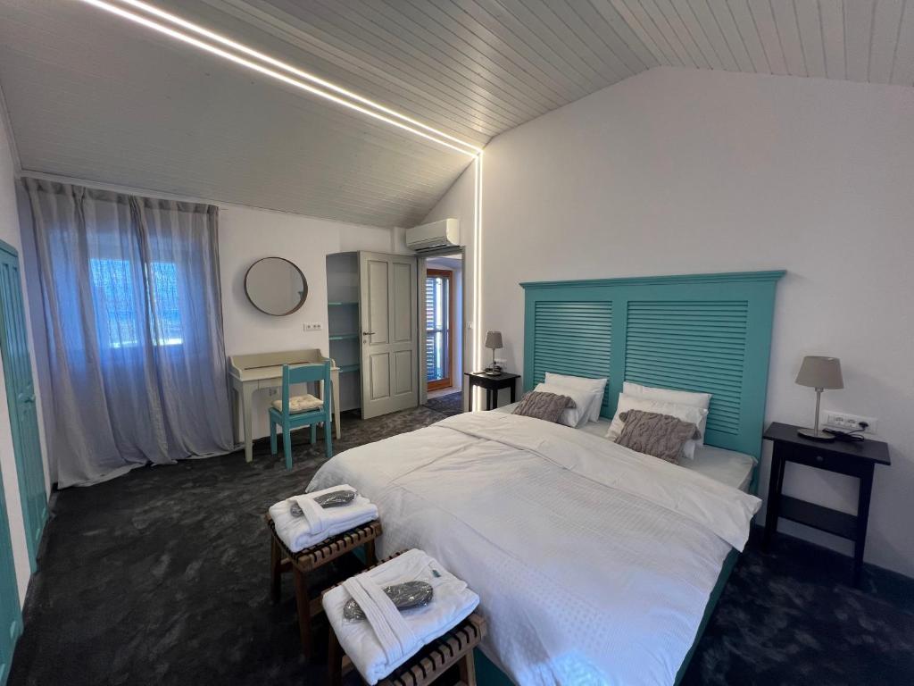 Podgora Experience Suite with jacuzzi في نيرازين: غرفة نوم مع سرير كبير مع اللوح الأمامي الأزرق