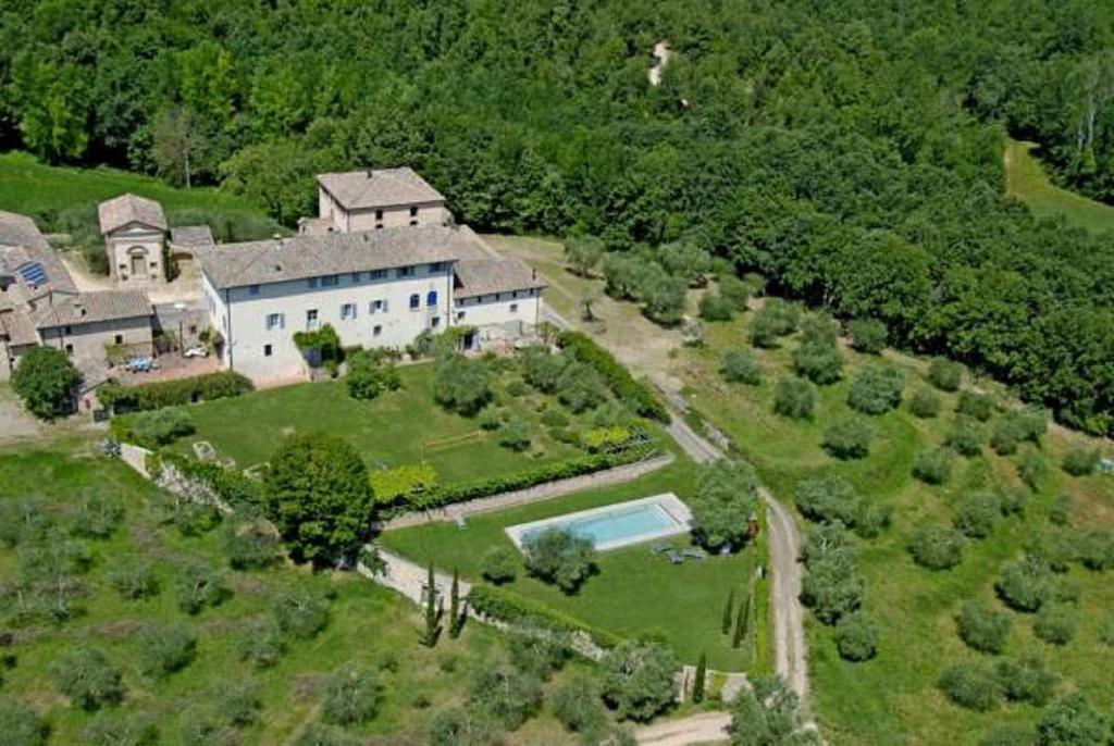 z góry widok na duży biały dom z basenem w obiekcie Agriturismo Borgo Personatina w mieście Sovicille