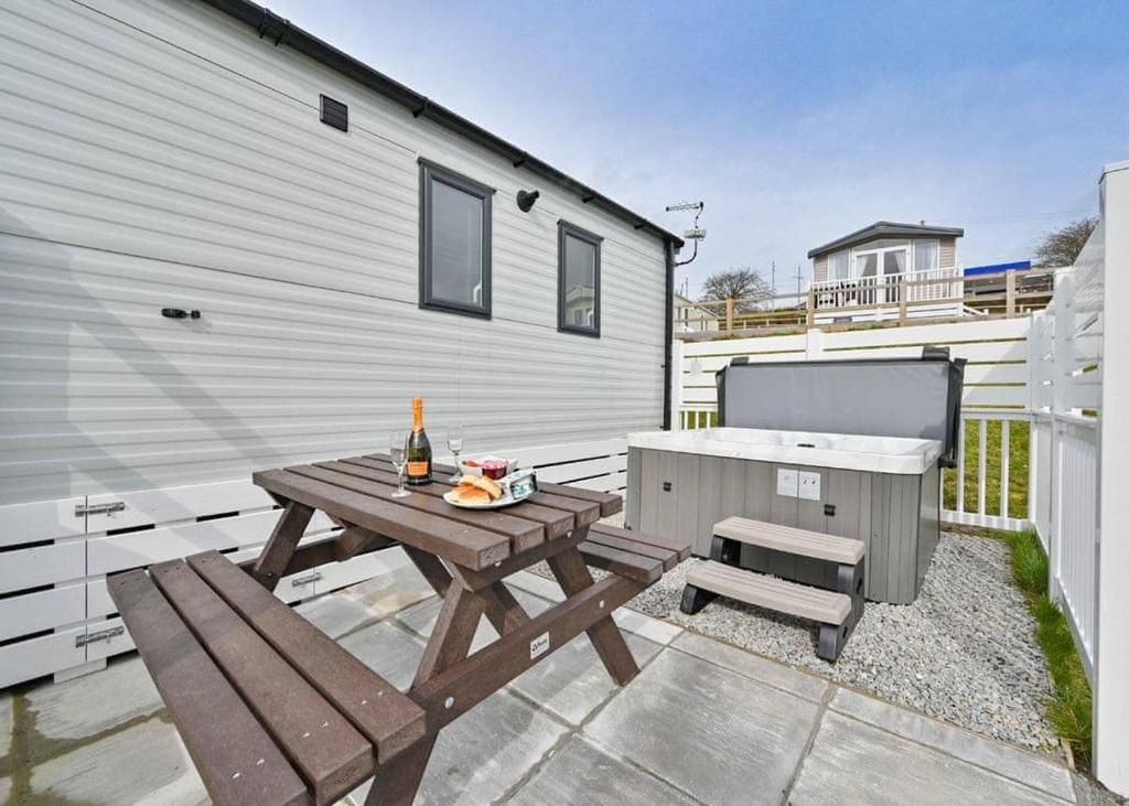 a patio with a picnic table and a barbecue at Tamar View Holiday Park in Gunnislake