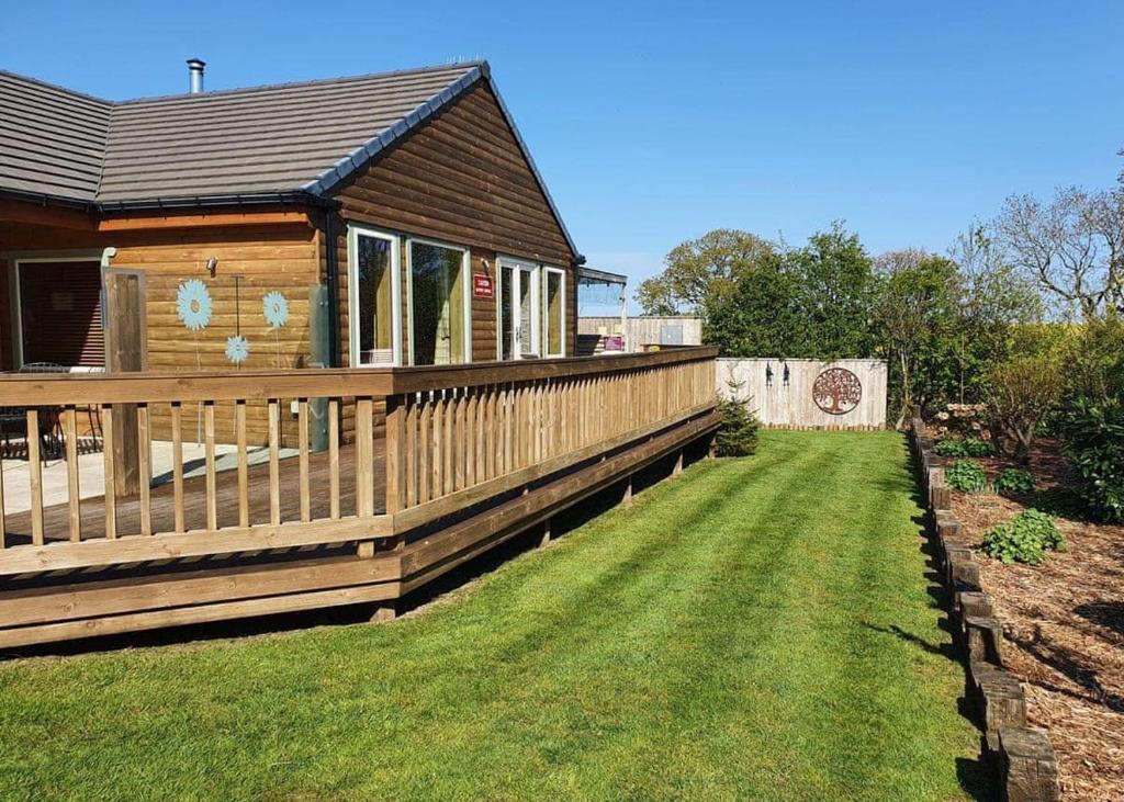 a house with a wooden fence and a yard at Durham Coastal Lodges in Haswell