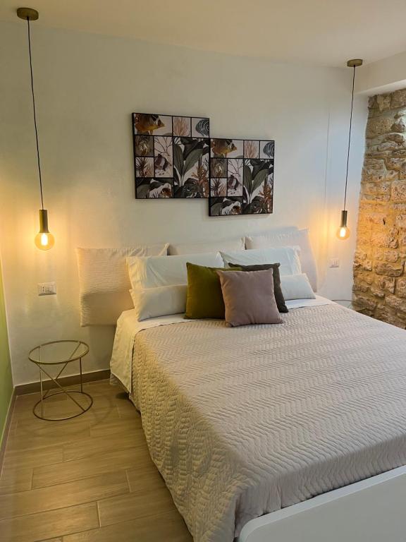 a bedroom with a large bed with two pictures on the wall at La Pelliccia in Bari
