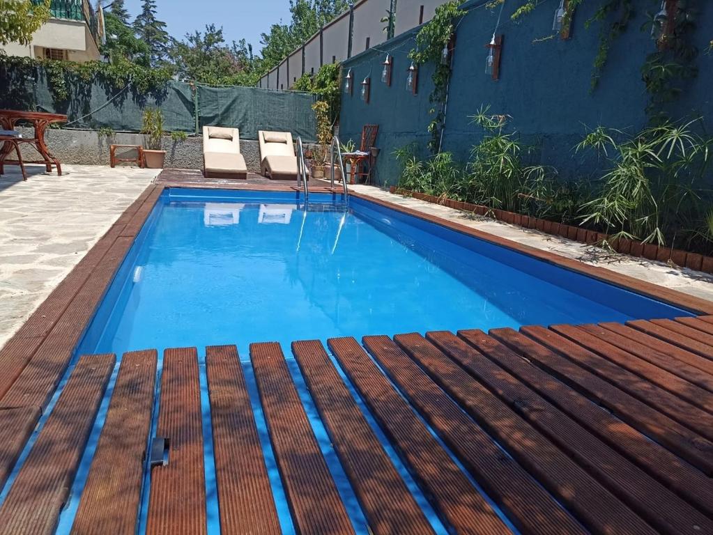 a swimming pool with blue water and a wooden deck at Atamert Homes in Kemer