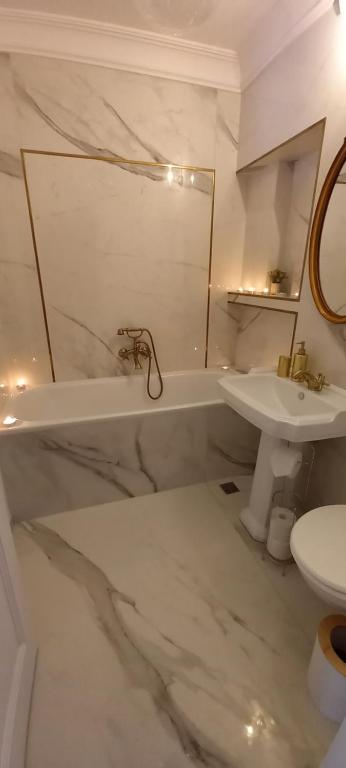 Baño blanco con lavabo y aseo en Sunny Apart Hereditas, en Ipoteşti