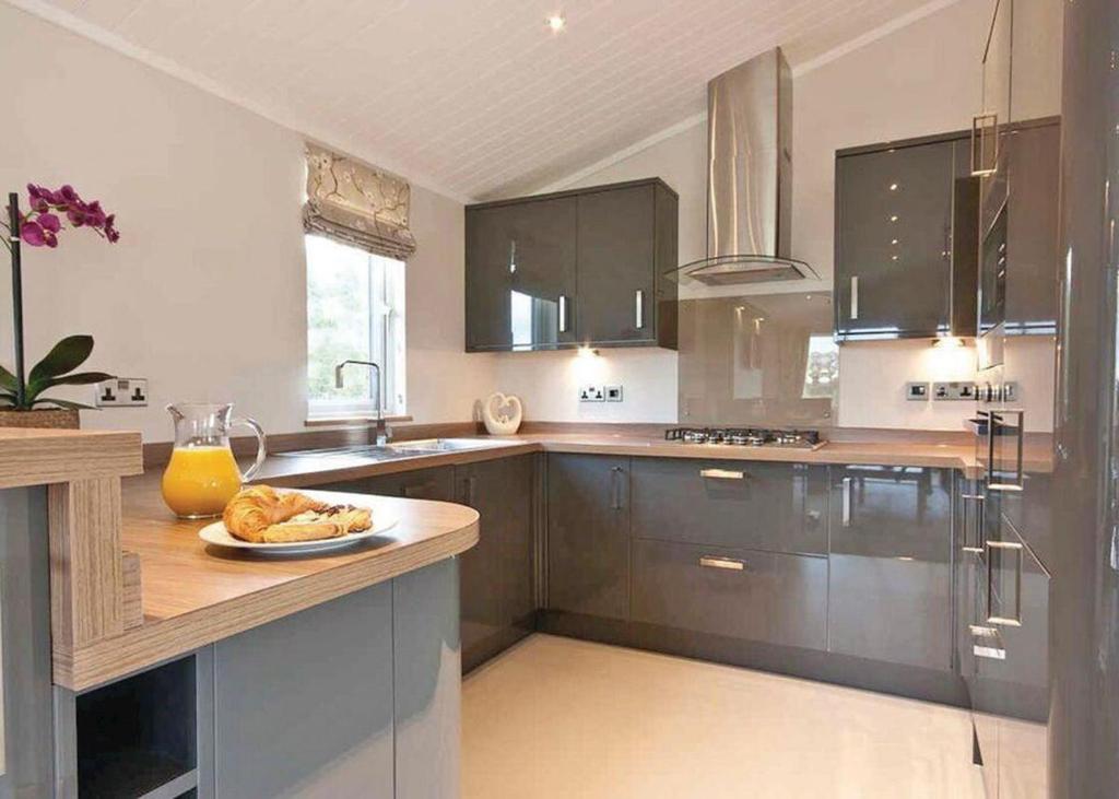 una cocina con armarios marrones y un plato de comida en una barra en Ribble Valley View en Langho