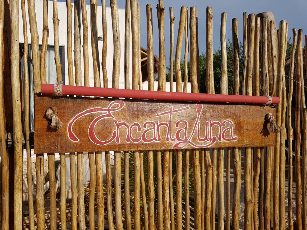 a wooden bench with a sign on it at EncantaLuna in Holbox Island