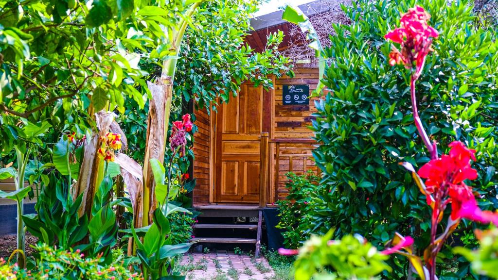 drewniane drzwi w ogrodzie z kwiatami w obiekcie Lemon Garden Lodge w mieście Çıralı