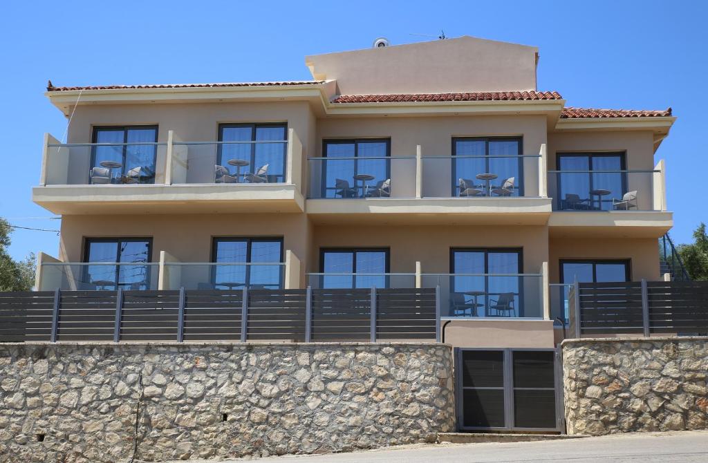 a building with balconies on a stone wall at Armonia Rooms in Laganas