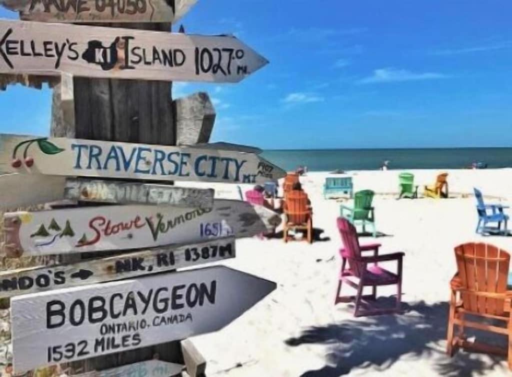 een bord op een strand met stoelen en de oceaan bij Everglades Breath 3bed 2 bath Villa in Port Charlotte