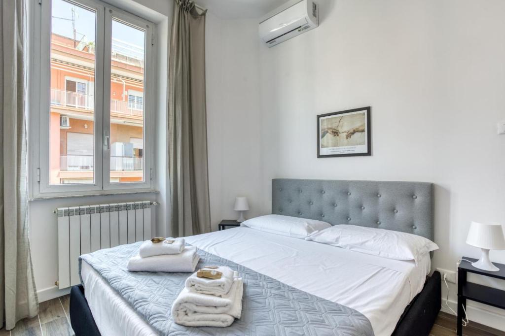 een slaapkamer met een groot bed en handdoeken bij Appio Deluxe Apartment in Rome