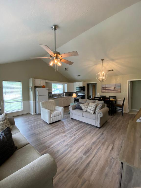 a living room with two couches and a ceiling fan at Cottage on Shalin Circle in Woodville