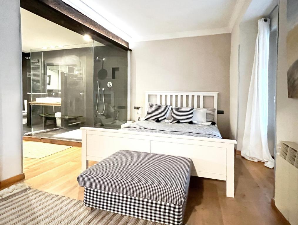 1 dormitorio con cama blanca y ducha en Luxury Arquillos Vitoria, en Vitoria-Gasteiz