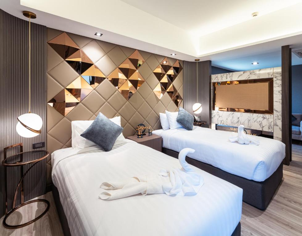 A twin room with two beds, decorative headboard panels and hotel styling.