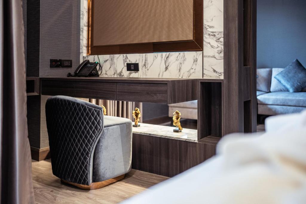 A small desk and upholstered chair sit beside the living area.