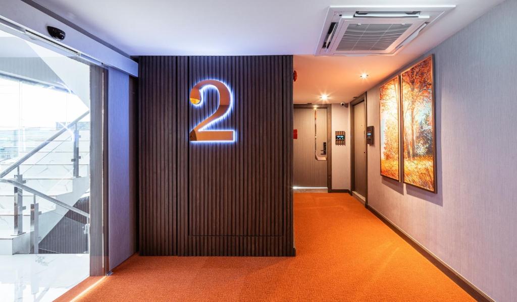 A second-floor elevator landing opens onto a bright stairwell and guest corridor.