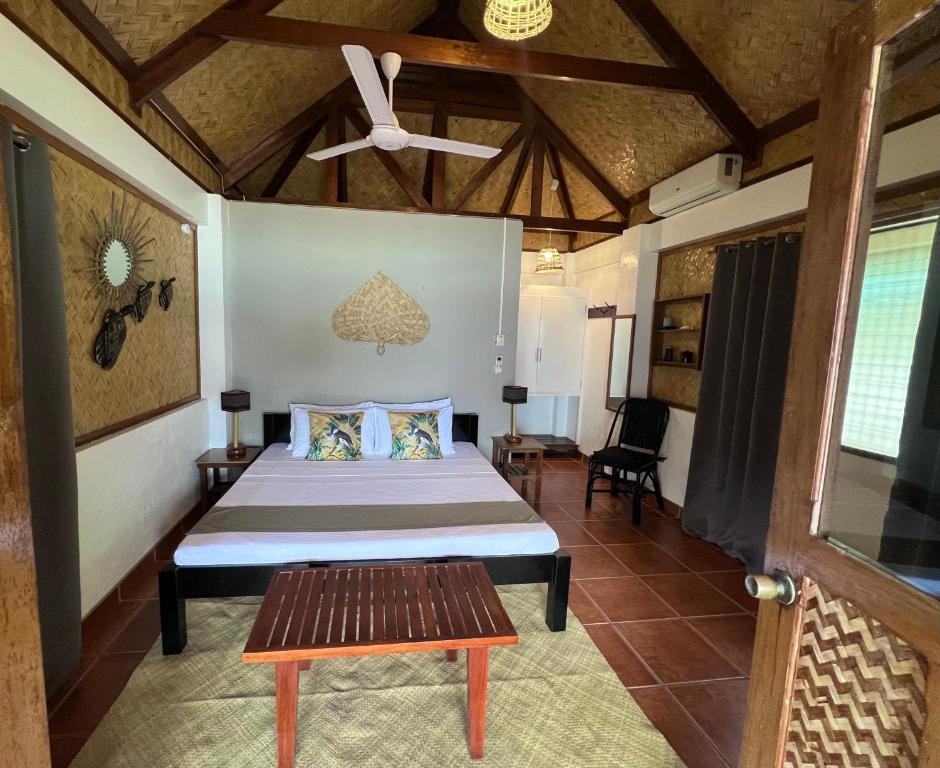 a bedroom with a bed and a ceiling fan at Golden Monkey Beach Hotel in El Nido
