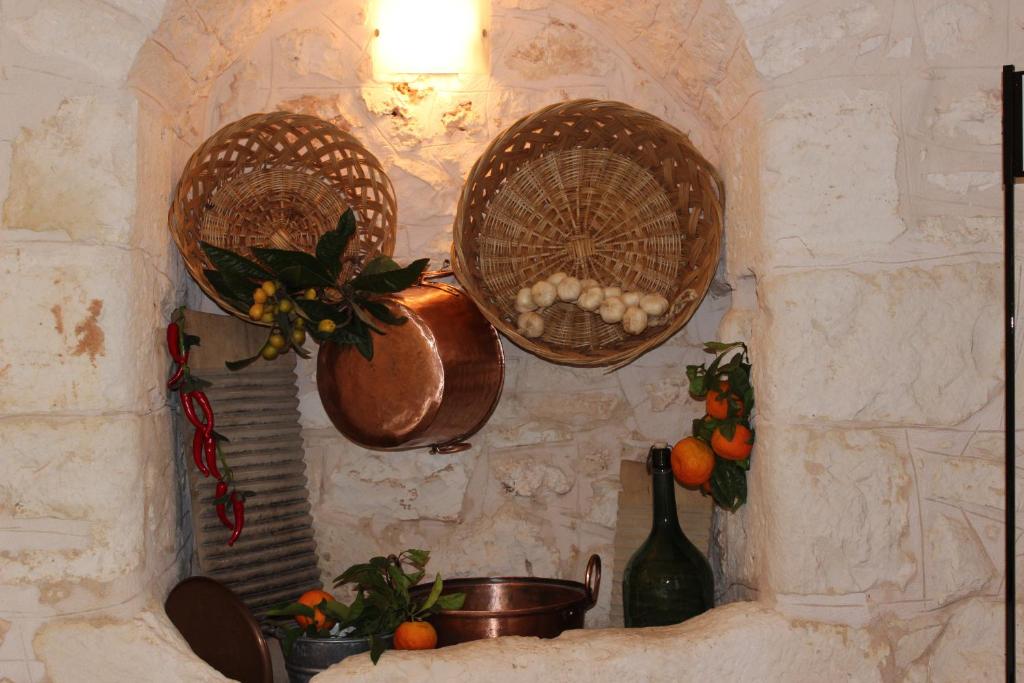 three baskets are hanging on a stone wall at Masseria Valente in Ostuni