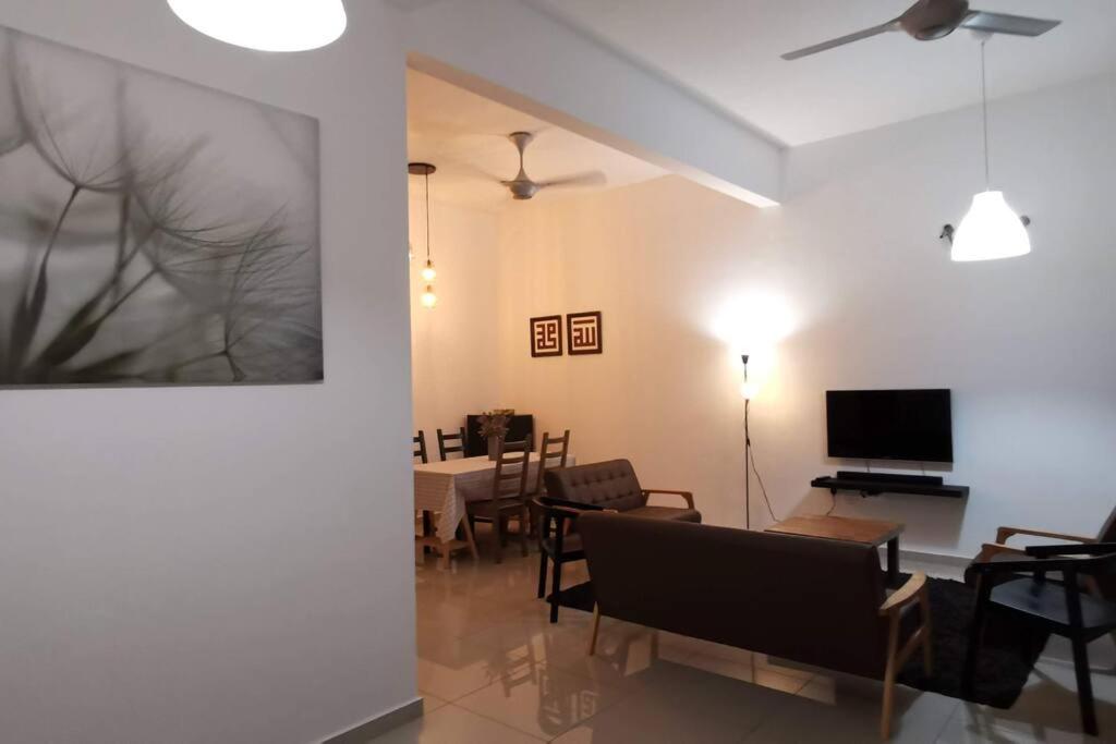 uma sala de estar com um sofá e uma sala de jantar em The Dandelion Homestay em Baling