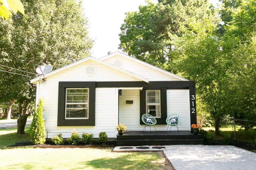 a small white house with two chairs in a yard at The WILLA on 7th, located in Downtown BENTONVILLE! in Bentonville