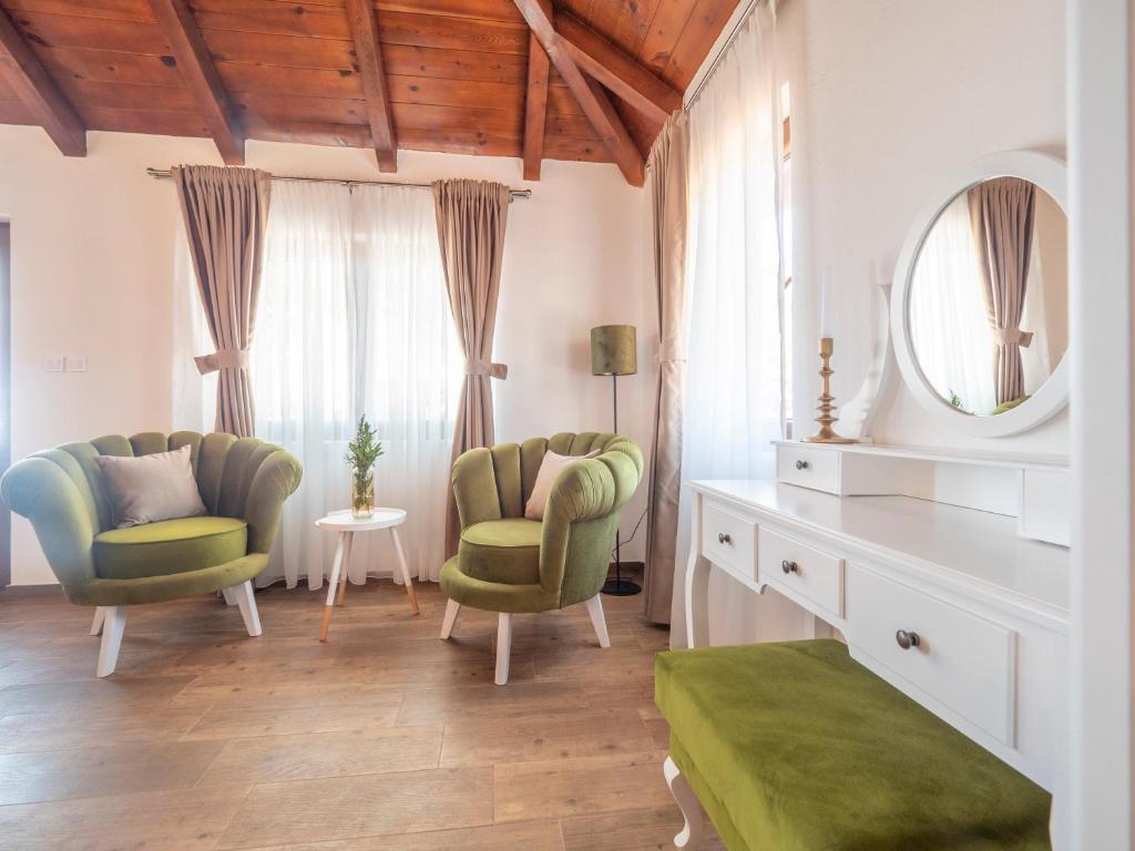 a living room with two chairs and a mirror at Harmonia Bungalows & Pool in Sveti Stefan
