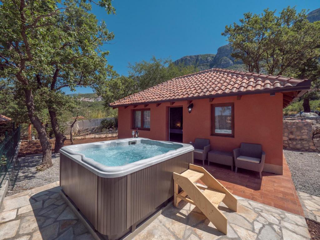a hot tub in front of a small house at Harmonia Bungalows & Pool in Sveti Stefan