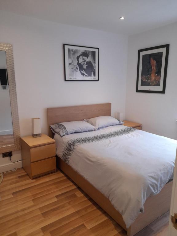 a bedroom with a bed and two pictures on the wall at Lovely Home with full en-suite double bed rooms in Reading