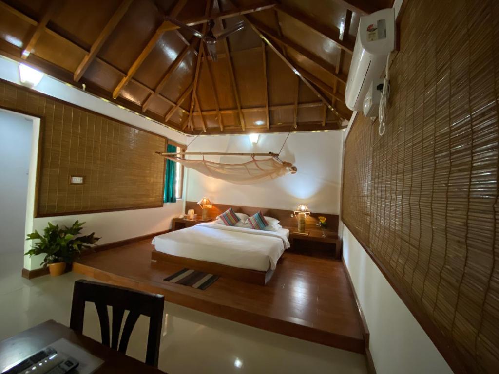 - une chambre avec un lit et un bureau dans l'établissement Wild Orchid, à Havelock Island