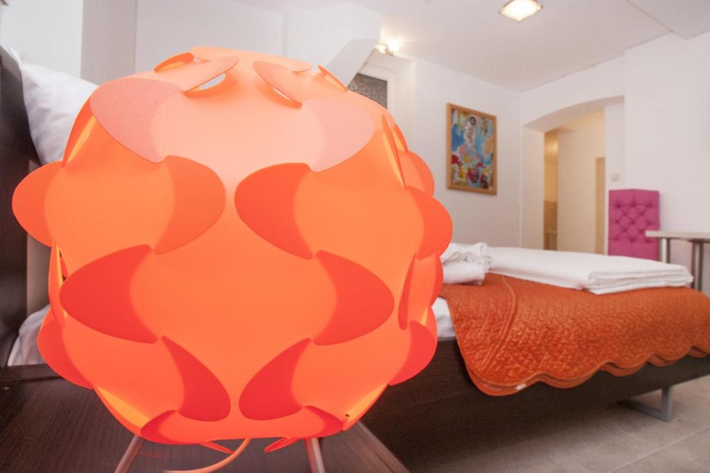 um quarto com uma cama e uma grande escultura em laranja em Atelier 1 Apartment em Belgrado