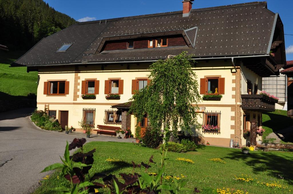 a large white house with a black roof at Haus Garz in Weissensee