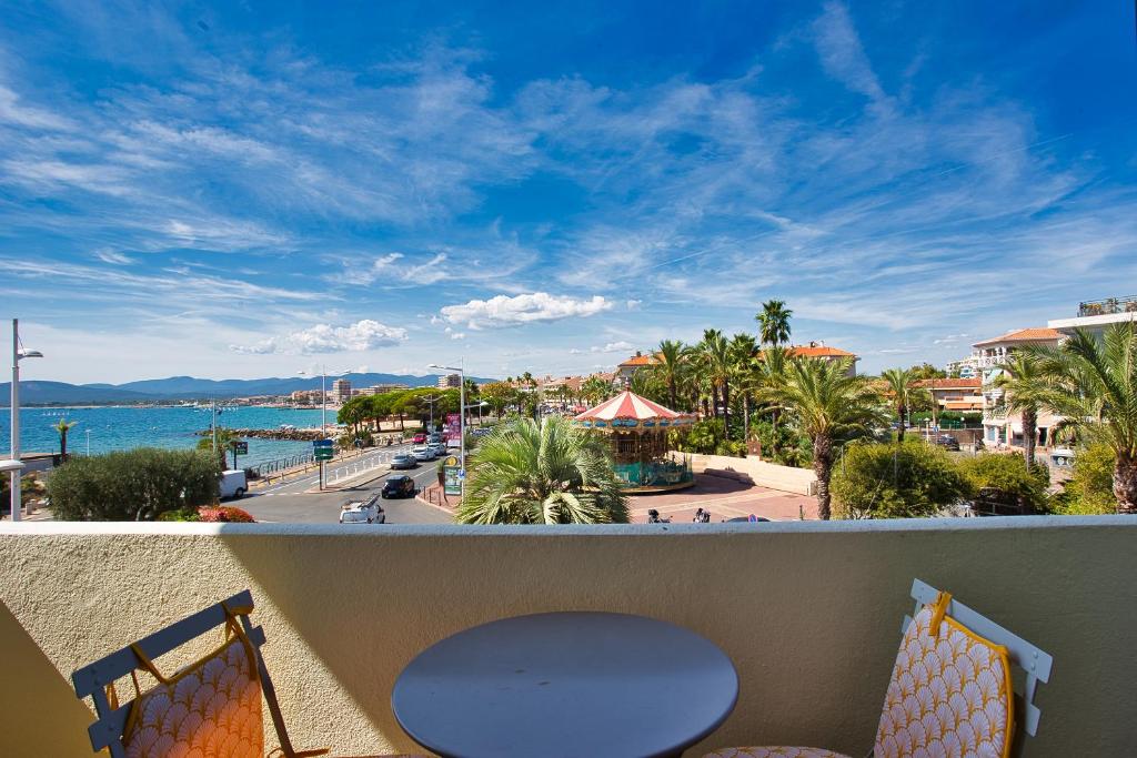 ein Balkon mit Tisch und Stühlen und Blick auf das Meer in der Unterkunft Le Belvédère du Vieux Port Plages centre et gare à pied in Saint-Raphaël
