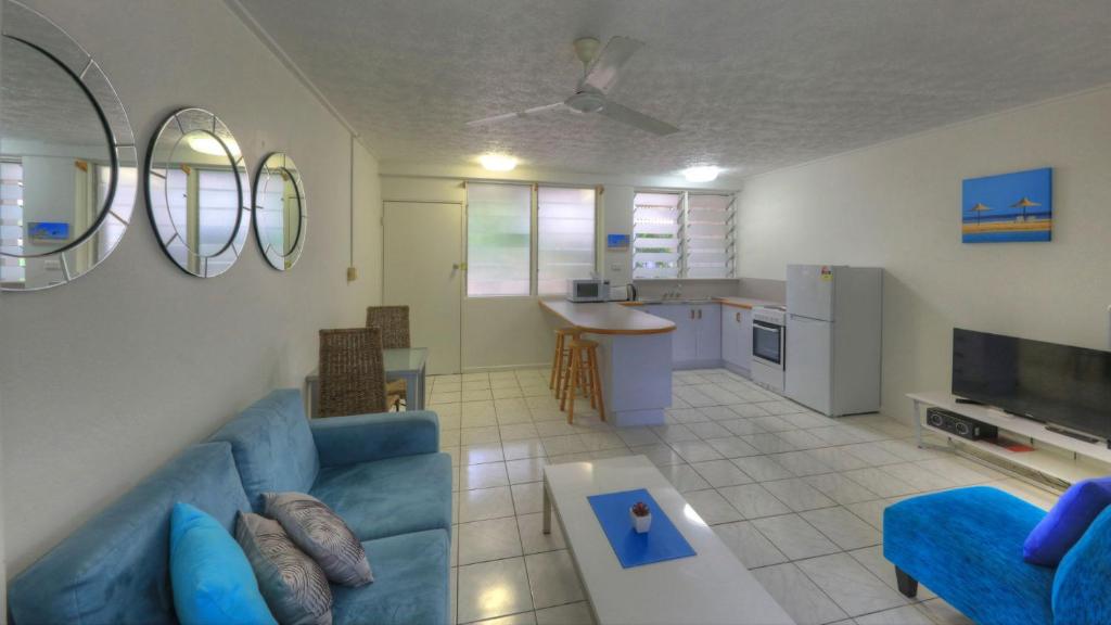 a living room with a blue couch and a tv at Loyang Apartment 1 in Arcadia