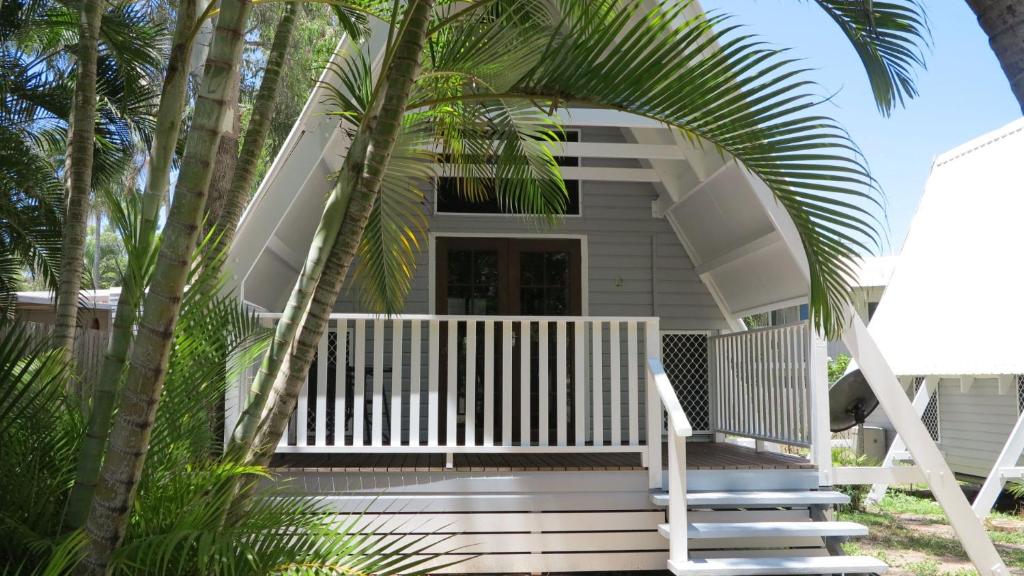 a house with a white porch and stairs leading to it at Picnic Bay Chalet Unit 2 in Picnic Bay