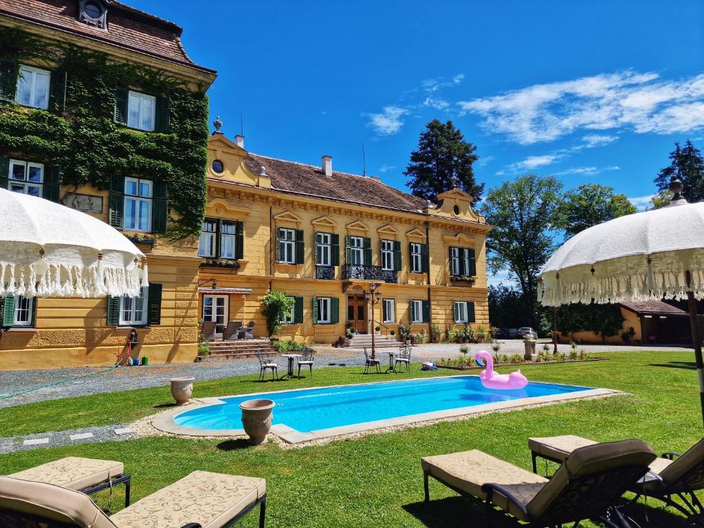 une grande maison avec une piscine en face de celle-ci dans l'établissement Palais Kneissl, à Burgau