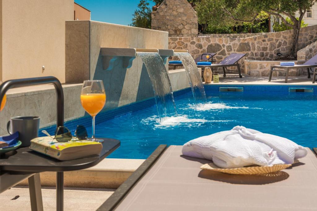 una copa de vino en una mesa junto a la piscina en Casa Laurea en Dubrovnik