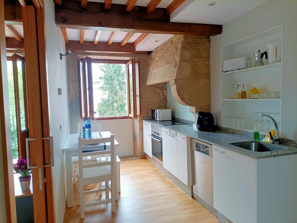 a kitchen with white cabinets and a counter top at Bico de Pedra in Santiago de Compostela